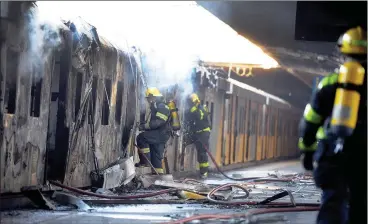  ?? Picture: Ayanda Ndamane/African News Agency (ANA) ?? WRECKAGE: Firefighte­rs battle to extinguish a fire on one of two trains that were allegedly set alight at the Cape Town Central train station at the weekend.