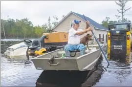  ?? Jason Lee Sun News ?? LEE BERTRAND paddles through f looded equipment in his yard in Longs, S.C. “Florence is gone, but the storm’s devastatio­n is still with us,” one official said.