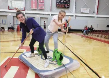  ?? COURTESY OF PERRY SCHOOLS ?? From left, juniors Allanah Cooper and Ravyn Furst guide their hovercraft across the Perry High School basketball court.