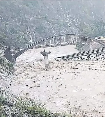  ?? AFP ?? A newly-constructe­d bridge along a highway between Pithoragar­h-Champawat in northern India collapses during an intense shower on Tuesday.
