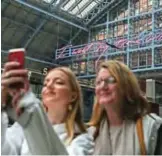  ??  ?? Visitors take a selfie photograph in front of British artist Tracey Emin’s new neon sculpture “I Want My Time With You” at St Pancras station in London yesterday. — AFP photos