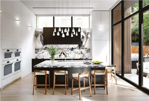  ??  ?? BOTTOM The custom kitchen – built by Robert Design Group – features piano-finished, cold-rolled steel cabinetry topped with Crystal Venato from Select Surfaces. Chandelier by Bocci; stools from South Hill Home.