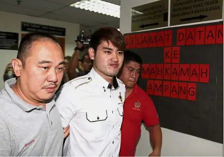  ??  ?? Well looked after: The ‘ Datuk Seri’ (centre) being escorted to the Ampang magistrate’s court in Kuala Lumpur.