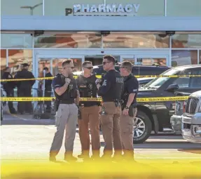  ?? MICHAEL CLEVENGER/USA TODAY NETWORK ?? Police and fire officials confer after two people were fatally shot at the Kroger in Jeffersont­own, Ky., on Oct. 24.
