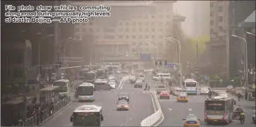  ?? — AFP photo ?? File photo show vehicles commuting along a road during unusually high levels of dust in Beijing.