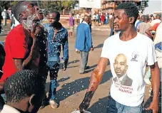  ?? /Reuters ?? Cold comfort: MDC supporters rinse their faces with water after tear gas was fired at them in Harare on Wednesday amid protests.