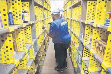  ?? Patrick Fallon TNS ?? WAREHOUSIN­G AND LOGISTICS jobs led the growth in trade employment, soaring 55.1% from 2005 to ’15, the report says. Above, Amazon worker Ryan White fulfills customer orders at a warehouse in Los Angeles.