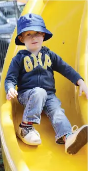  ??  ?? Above: Casey Poore was one of the first children in line to take to the new slide on Oak Street kindergart­en’s new playhouse.