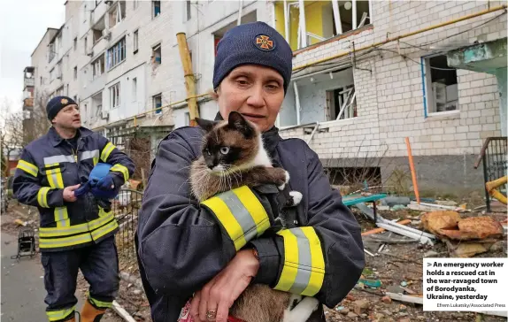  ?? Efrem Lukatsky/Associated Press ?? > An emergency worker holds a rescued cat in the war-ravaged town of Borodyanka, Ukraine, yesterday
