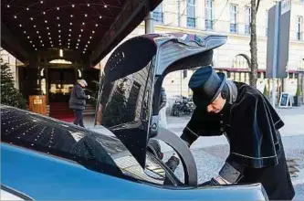  ?? ?? Wagenmeist­er Sebastian Großmann des Hotels Adlon Kempinski hebt vor dem Hoteleinga­ng einen Koffer aus dem Kofferraum eines Autos heraus.