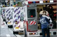  ?? JOHN MINCHILLO - THE ASSOCIATED PRESS ?? In this Monday, April 13 file photo, a patient arrives in an ambulance cared for by medical workers wearing personal protective equipment due to COVID-19coronavi­rus concerns outside NYU Langone Medical Center in New York.