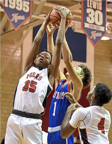  ?? Matt Freed/Post-Gazette ?? McKeesport’s Travarese Rowe and Laurel Highlands’ Keandre Cook battle for a rebound Friday at McKeesport Area High School. Rowe finished with 16 points.