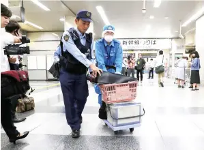  ??  ?? PEGAWAI polis berjalan keluar membawa troli di stesen Odawara, Kanagawa semalam, selepas memeriksa kereta api berkelajua­n tinggi di lokasi kejadian bunuh. — Gambar AFP