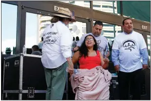  ?? AP/CEDAR ATTANASIO ?? Jessica Coca Garcia (center), who was wounded in the El Paso, Texas, shooting, meets with participan­ts of the march held Saturday. “Racism is something I always wanted to think didn’t exist,” she said after rising from her wheelchair to address attendees. “Obviously, it does.”
