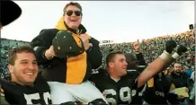  ?? CHARLIE NEIBERGALL — THE ASSOCIATED PRESS FILE ?? Iowa coach Hayden Fry is carried off the field after his team defeated Minnesota in 1993, giving him his 200th career victory in Iowa City, Iowa.