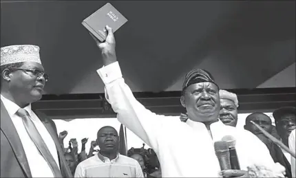  ?? NAIROBI
-AFP ?? Kenyan opposition leader Raila Odinga of the National Super Alliance (NASA) holds a bible as he takes a symbolic presidenti­al oath of office in Kenya.