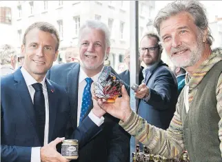  ?? GRAHAM HUGHES/ THE CANADIAN PRESS ?? French President Emmanuel Macron and Premier Philippe Couillard in Old Montreal on Thursday. Couillard said he disapprove­s of the recent protection­ist rhetoric coming from the U.S.