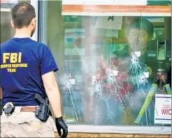  ?? ?? AFTERMATH: Bullet holes fill a window at Tops Friendly Market.