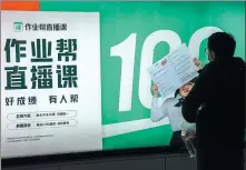  ?? PROVIDED TO CHINA DAILY ?? A man looks at a billboard of Zuoyebang in Shanghai on Dec 26. The online education startup raised $1.6 billion in its series E-plus round of funding in December.