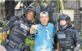  ??  ?? Joe Michel, 19, of Lawrencevi­lle, N. J., takes a selfie with two Charlotte Mecklenbur­g Police officers outside Bank of America Stadium for an NFL football game between the Minnesota Vikings and the Carolina Panthers on Sunday.