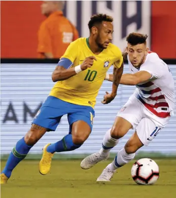  ?? — AFP ?? Brazil’s Neymar ( left) vies for the ball with USA’s Paul Arriola in their friendly match at the Metlife Stadium in East Rutherford, New Jersey on Friday. Brazil won 2- 0.