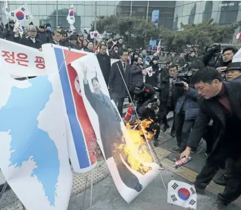  ?? AHN YOUNG-JOON/THE ASSOCIATED PRESS ?? South Korean protesters burn a portrait of North Korean leader Kim Jong Un during a rally against the visit of North Korean Hyon Song Wol, head of a North Korean art troupe, in front of Seoul Railway Station in Seoul, South Korea.