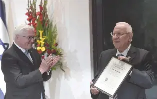  ?? (Koby Gideon/GPO) ?? GERMAN PRESIDENT Frank-Walter Steinmeier applauds as President Reuven Rivlin displays his father’s university diploma from the University of Frankfurt.