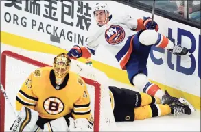  ?? Elise Amendola / Associated Press ?? Islanders center Jean-Gabriel Pageau trips over Bruins defenseman Charlie McAvoy, bottom, as Bruins goaltender Tuukka Rask guards the net on Thursday.