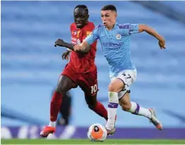  ?? (AFP) ?? Manchester City’s midfielder Phil Foden (right) vies for the ball with Liverpool’s striker Sadio Mane during the Premier League match in Manchester on Thursday.