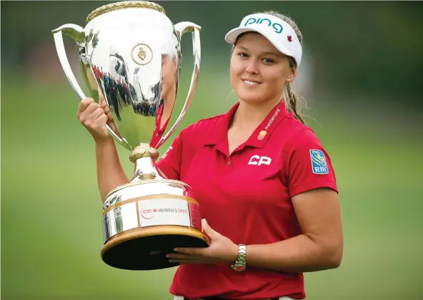  ?? TROY FLEECE ?? Brooke Henderson of Smiths Falls, Ont., hoisted the championsh­ip trophy after becoming the first homegrown Canadian since 1973 to capture the LPGA CP Women’s Open Aug. 26 at the Wascana Country Club in Regina. Henderson is this year’s Postmedia Female Athlete of the Year for the third time in four years.