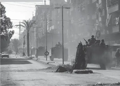  ?? JOSEPH EID/AFP/GETTY IMAGES ?? Lebanese army soldiers patrol Syria Street in Tripoli, Lebanon, in 2013. Area hostilitie­s have roots stretching back to Lebanon’s civil war of 1975-90 and they have become far more acute because of the Syria’s own civil war.