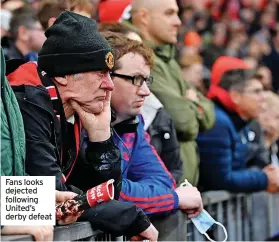  ?? ?? Fans looks dejected following United’s derby defeat