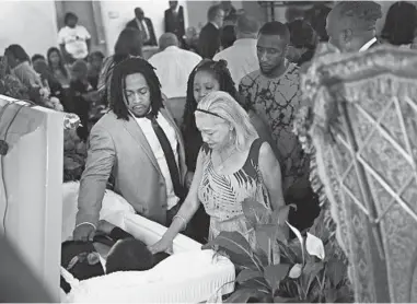  ?? SCOTT OLSON/GETTY ?? Dion Green, left, bids farewell Saturday to his dad, shooting victim Derrick Fudge, in Ohio.