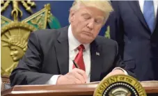  ?? | SUSAN WALSH/ AP ?? President Donald Trump signs an executive order on extreme vetting during an event at the Pentagon on Friday.