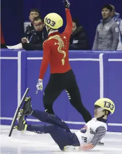  ?? — AP ?? SAPPORO: Wu Dajing, top, of China celebrates his victory as Seo Yi-ra, bottom, of South Korea falls down after the men’s 500 meters finals of short track speed skating competitio­n at the Asian Winter Games at Makomanai Indoor Skating Rink in Sapporo,...
