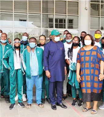  ??  ?? Minister of Sports, Sunday Dare poses for a photograph with athletes and officials of the relay team at the Murtala Muhammed Internatio­nal Airport in Lagos before their departure for the USA yesterday