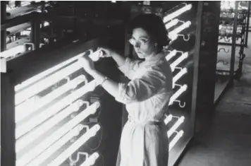  ??  ?? A worker checks fluorescen­t lighting units at the Phlilps factory in 1947
