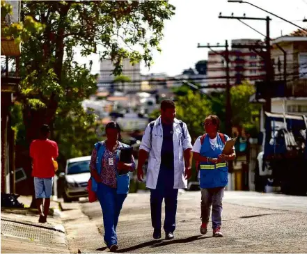  ?? Adriano Vizoni/Folhapress ?? Médico e agentes de saúde da família percorrem até 30 quarteirõe­s para acompanhar pacientes