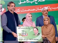  ??  ?? Prime Minister Shahid Khaqan Abbasi distributi­ng health cards at the launch of PM’s National Health Programme in Hafizabad. APP