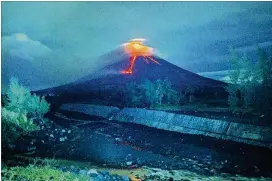  ?? DAN AMARANTO / ASSOCIATED PRESS ?? Lava cascades down the slopes of the Mayon volcano about 210 miles southeast of Manila, Philippine­s, on Tuesday. The Philippine Institute of Volcanolog­y and Seismology said the lava flowed as much as 1.2 miles from the crater.