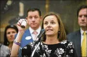  ?? ALYSSA POINTER / ALYSSA.POINTER@AJC.COM ?? Shannon Cloud, a parent of a child who suffers from seizures, holds up a bottle of THC oil during a news conference at the Georgia State Capitol on Thursday. She supports legislatio­n for growing and distributi­ng medical marijuana.