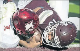  ?? [STEPHEN B. MORTON/THE ASSOCIATED PRESS] ?? Mississipp­i State freshman quarterbac­k Keytaon Thompson, right, scores one of his three touchdowns in a win over Louisville in the TaxSlayer Bowl.