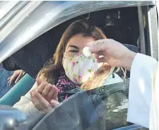  ??  ?? Las personas acudían en autos para recibir la comunión, luego podían dejar dinero como ofrenda a la parroquia.