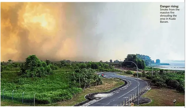  ??  ?? Danger rising: Smoke from the massive fire shrouding the area in Kuala Baram.