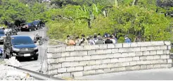  ?? —FILE PHOTO ?? FENCED Residents and local officials check out the concrete wall erected across Insular Road by the Bureau of Correction­s supposedly for security reasons.