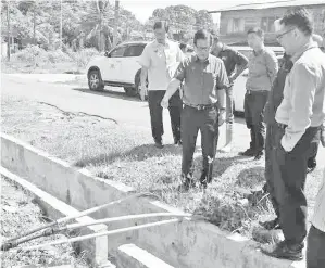  ??  ?? LEE (dua kiri) ketika meninjau pembinaan sistem parit konkrit di Kampung Pujut Tanjong Batu di Miri, semalam, sambil diiringi Ir. Chai (kiri) serta Morshidi (kanan) dan yang lainnya.