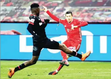  ?? POOL/AFP ?? Bayern Munich’s Polish forward Robert Lewandowsk­i (right) shoots to score the 1-2 during the German first division Bundesliga football match Bayer Leverkusen v FC Bayern Munich in Leverkusen on Saturday.