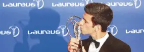  ?? AP ?? Serbian tennis player Novak Djokovic kisses the Laureus World Sportsman of the Year award at the Laureus World Sports Awards in Berlin, Germany.