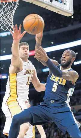  ?? Ringo H.W. Chiu Associated Press ?? THE LAKERS’ Brook Lopez hounds the Nuggets’ Will Barton as he tries to pass the ball. Lopez was tough on the offensive end as well, scoring 21 points.