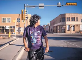  ??  ?? Isaiah Izzy, 17, rides home through downtown Gallup May 1, shortly before the city was placed on lockdown.